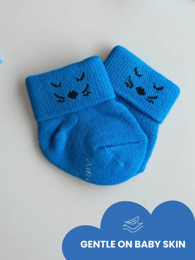 Air Garb brand baby combo socks for infants 0-1 years; a 6-pair collection arranged in a circle featuring three pairs with side flower designs (pink, yellow, mint) and three pairs with kitten face cuffs (purple, lime green, blue).